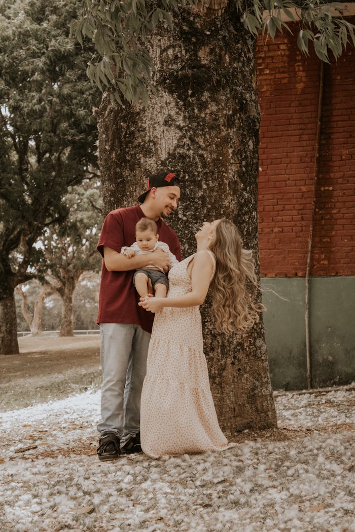A loving family shares a joyous moment under a tree in a São Paulo park.