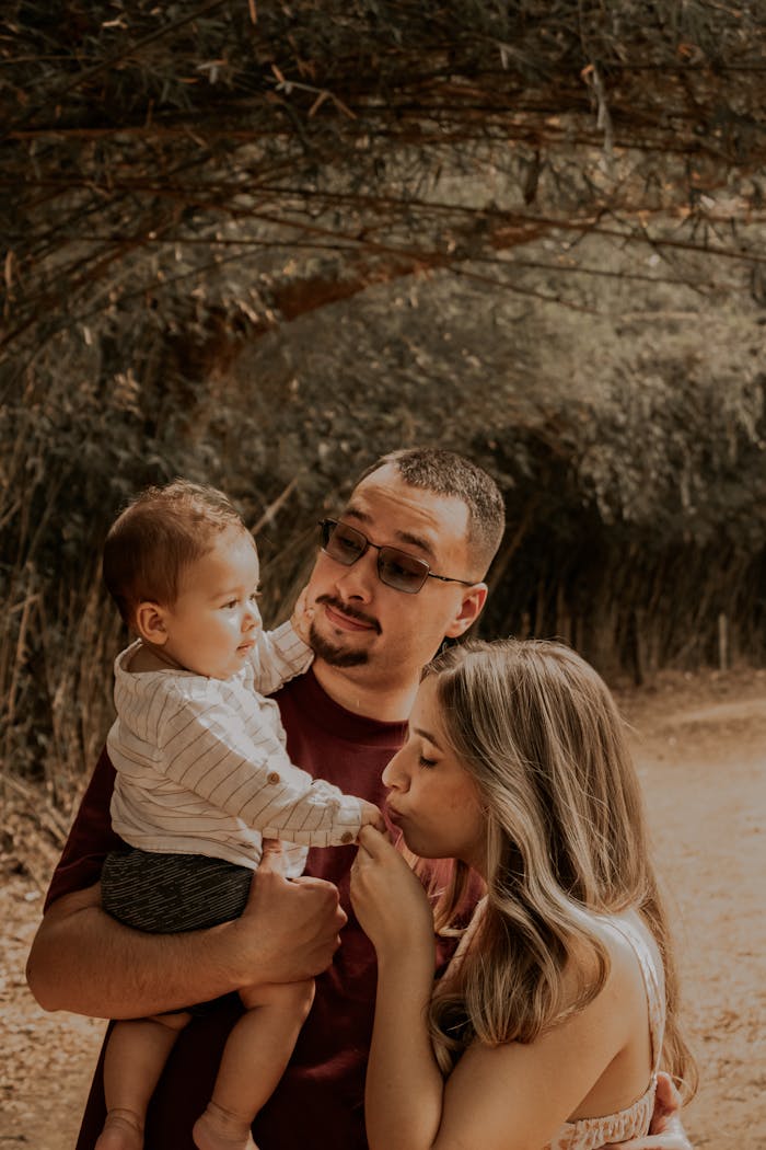 A family enjoying a warm autumn day outdoors with a loving interaction.